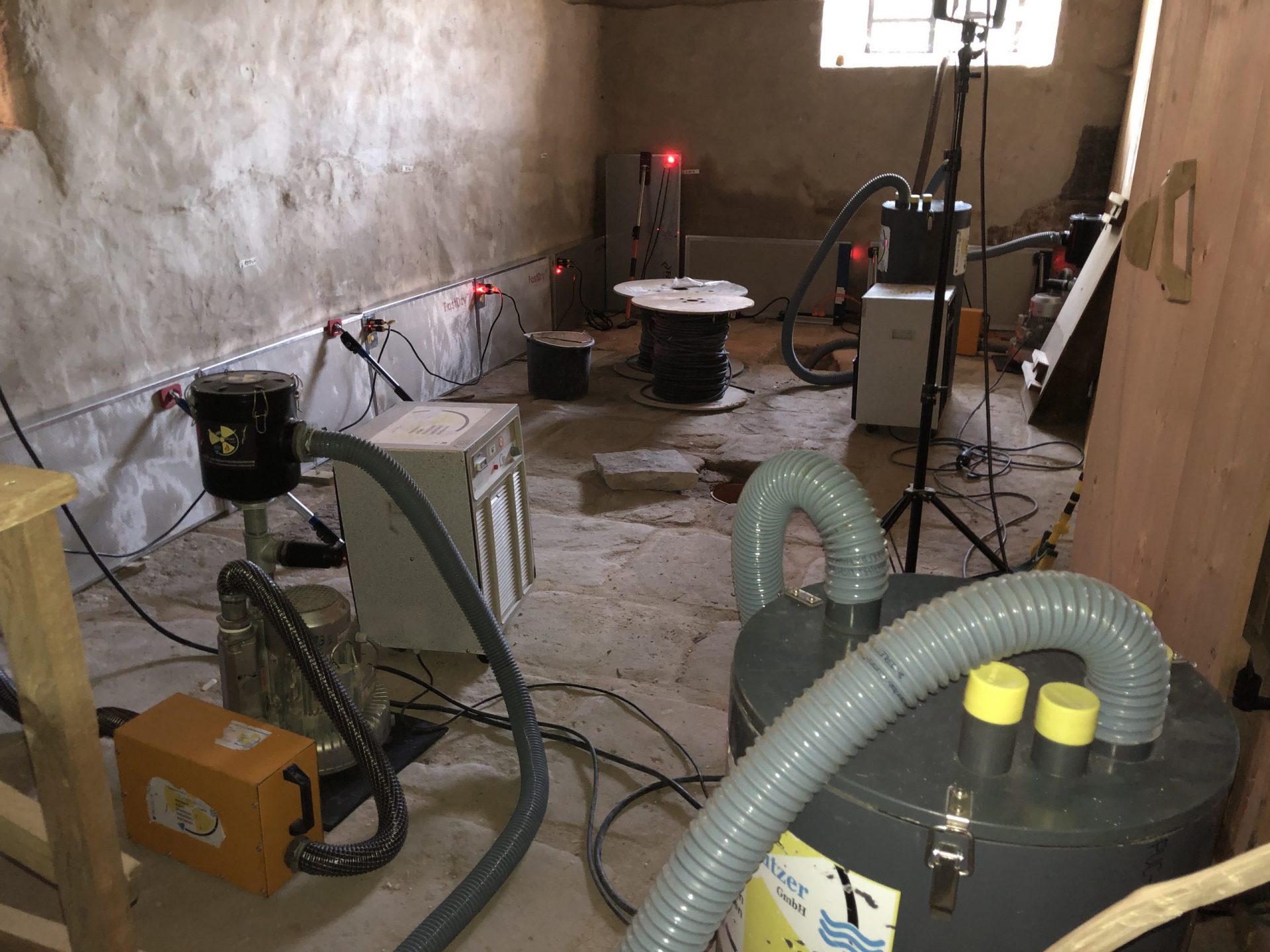 Trocknungs- und Wasserabsauggeräte im Badhaus aus Wendelstein. An der Wand die „FastDry“-Trocknungsmodule, die das Fraunhofer Institut zur Verfügung gestellt hat. (Foto: Herbert May)