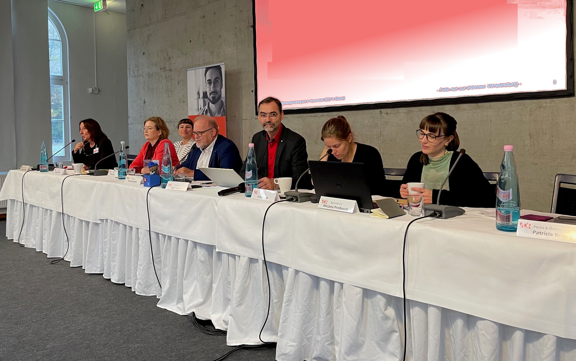 Das Präsidium und die Geschäftsführung auf dem Podium.