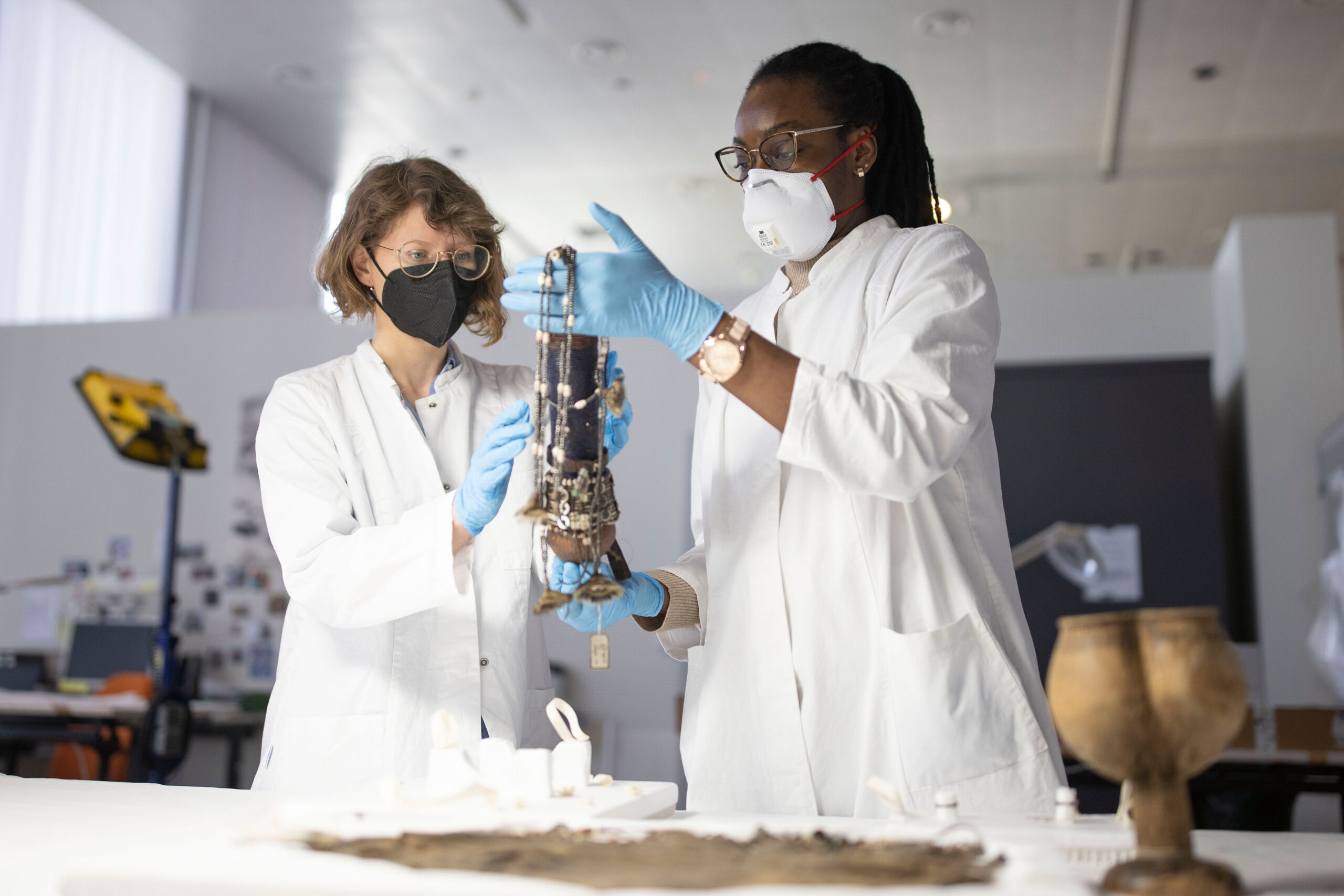 Restauratorin Johanna Ndahekelekwa Nghishiko und Julia Binter bereiten die Objekte auf ihre Reise nach Namibia vor im Museumszentrum Berlin-Dahlem (© SPK, Foto: Axel Schmidt/photothek.net)