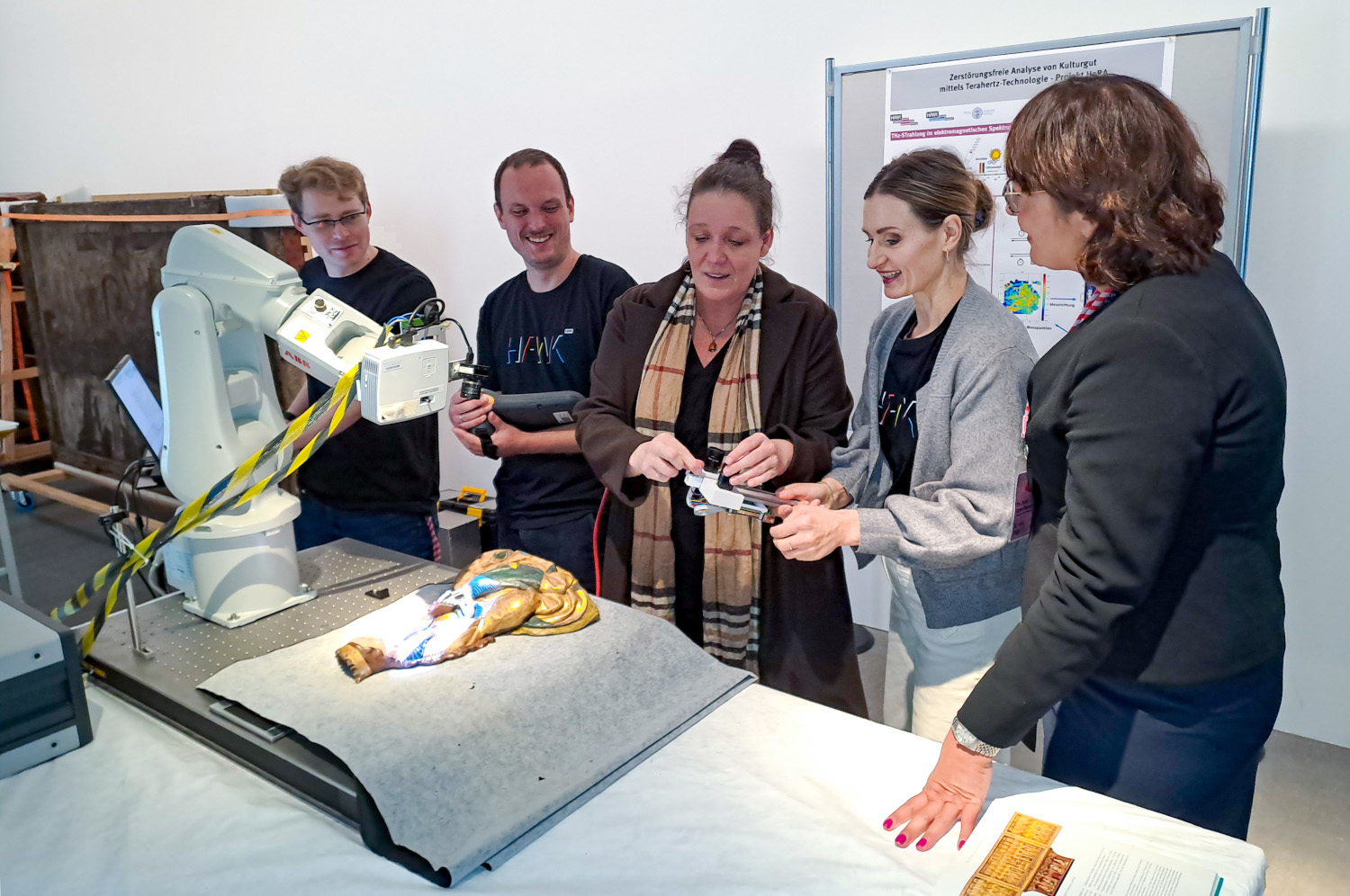 Dr.-Ing. Dipl.-Rest. Kirsti Krügener zeigt ein THz-Handheldsystem (Mitte) im Beisein von (v.l.) Cornelius Mach, 
Tobias Hofmann, sowie  Roksana Jachim und Dr. habil Lara Weiss (RPM).
©HAWK Pressestelle, Alissa Lange