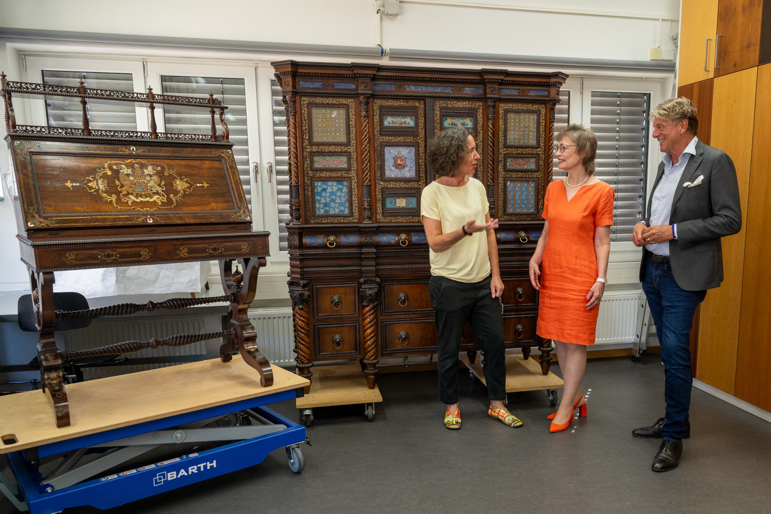 Prof. Dr. Julia Schultz, Prof. Katja Scholz-Bürig und Dr. Mario Mathias Ohle vor dem sogenannten Hochzeitsschrank und dem Sekretär von Schloss Marienburg.