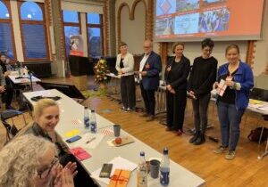 Das neue Präsidium 2025, v.li.: Nadine Thiel (Präsidentin), Dirk Sturmfels (Vize), Katharina Klauke (Präsidiumsmitglied), Isabel Wagner (Präsidiumsmitglied) und Julia Brandt (Vize und Schatzmeisterin). Im Vordergrund sind die wiedergewählten Kassenprüferinnen zu sehen.